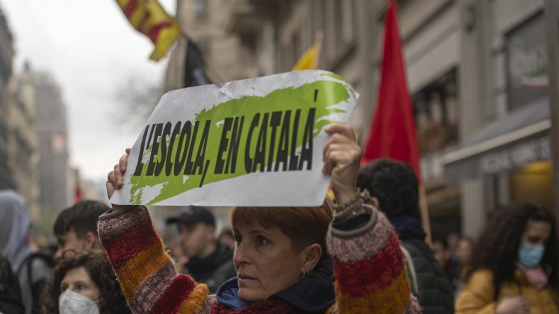 Una manifestante con una pancarta que reza 'L'escola, en catalá', en una huelga por la sentencia del 25% en castellano en la educación catalana, a 23 de marzo de 2022, en Barcelona.