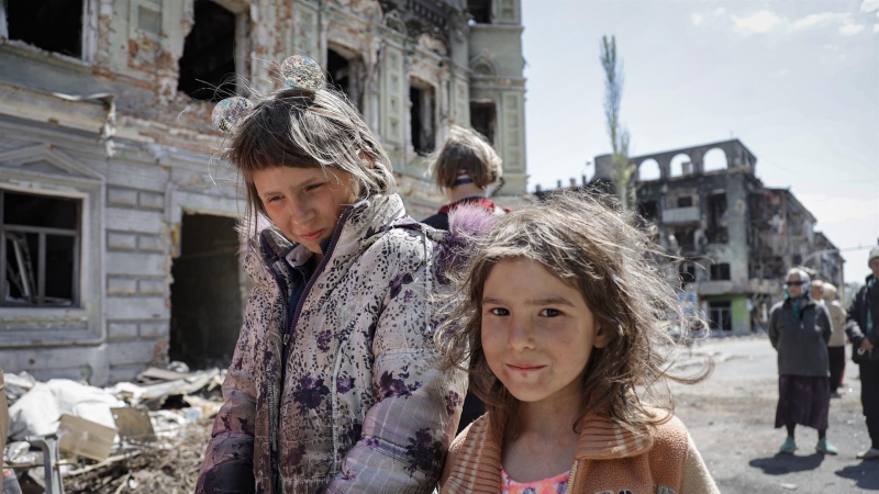 Dos niñas caminan por las ruinas de la ciudad devastada de Mariúpol (Ucrania) durante el Día de la Victoria, este 9 de mayo de 2022.