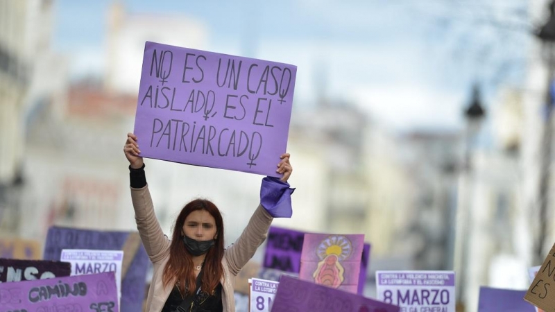 Una joven con un cartel en una manifestación estudiantil feminista por el 8M, Día Internacional de la Mujer, en la Puerta del Sol, a 8 de marzo de 2022, en Madrid