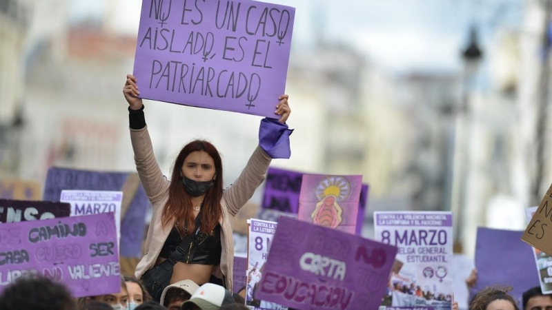 Una joven con un cartel en una manifestación estudiantil feminista por el 8M, Día Internacional de la Mujer, en la Puerta del Sol, a 8 de marzo de 2022, en Madrid