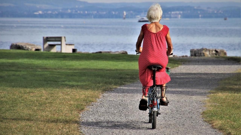 Una mujer pasea en bici camino de la playa.