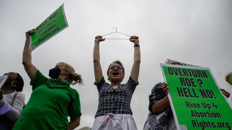 Un manifestante sostiene una percha, un símbolo del movimiento por los derechos reproductivos, mientras los activistas organizan una protesta de 'muerte' en el parque Washington Square en Nueva York el 13 de mayo de 2022.
