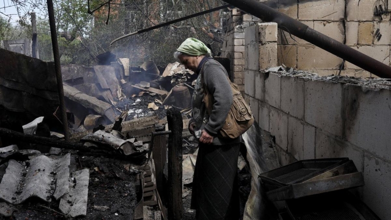 14/05/2022 Vera Kosolopenko camina entre los escombros de su vivienda, destruida por los bombardeos rusos en Derhachi, cerca de Járkov (Ucrania)