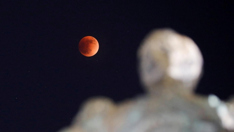 Una luna llena se mueve a través de la sombra de la tierra durante un eclipse lunar de 'luna de sangre' en San Salvador, El Salvador, 15 de mayo de 2022.