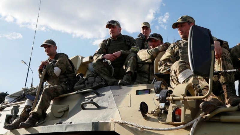 17/05/2022 - Miembros del servicio de las tropas prorrusas esperan encima de un vehículo blindado de transporte de personal ante la evacuación de los soldados ucranianos heridos de la asediada fábrica de acero Azovstal, Mariúpol.