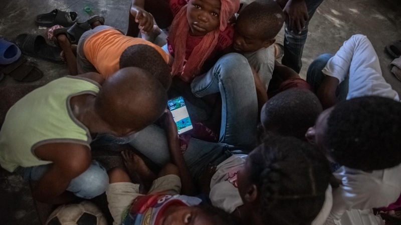 19/05/2022 - Imagen de varios niños haitianos que juegan con el móvil y no asisten al colegio, el 17 de mayo de 2022, en un albergue para refugiados en la comuna de Tabarre, distrito de Puerto Príncipe (Haití).