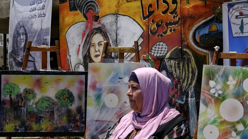 19/05/2022-Una mujer se encuentra este viernes 19 de mayo delante de un mural, que forma parte de una exposición de arte en honor a la periodista Shireen Abu Akleh, en el lugar donde fue asesinada