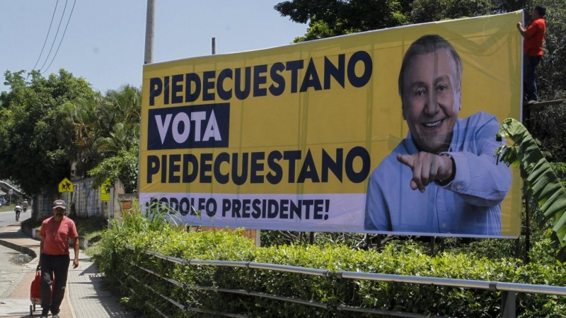 Un hombre camina junto a una vaya de campaña del candidato presidencial independiente, exalcalde de Bucaramanga Rodolfo Hernández, en Piedecuesta (Colombia). EFE/ Marco Valencia