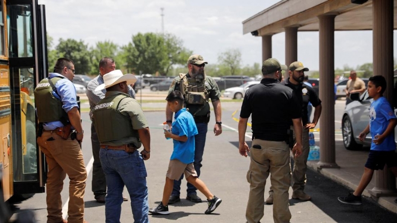 Los niños se suben a un autobús escolar mientras el personal policial vigila la escena de un presunto tiroteo cerca de la Escuela Primaria Robb en Uvalde, Texas, EE. UU. 24 de mayo de 2022.