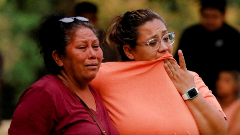 Dos mujeres esperan fuera del Centro Cívico Ssgt Willie de Leon, donde los estudiantes habían sido transportados desde la Escuela Primaria Robb después de un tiroteo, en Uvalde , Texas, EEUU.