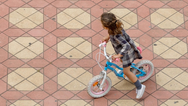 Una niña jugando con su bicicleta en la Plaza de España del Parque de Maria Luisa, en Sevilla.