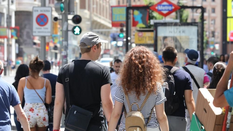 27/05/2022. Una pareja cruza de la mano un paso de peatones de la Gran Vía de Madrid, a 2 de junio de 2019.