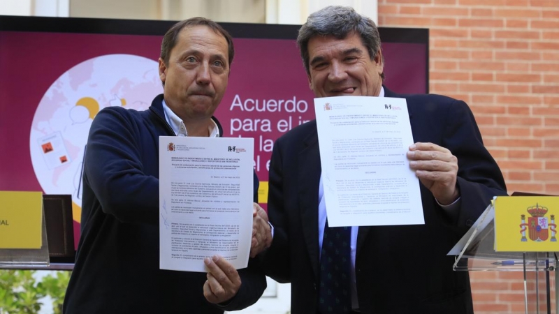 El ministro de Inclusión, Seguridad Social y Migraciones, José Luis Escrivá, y el presidente de Reporteros Sin Fronteras, Alfonso Bauluz, muestran el documento firmado del acuerdo de colaboración.