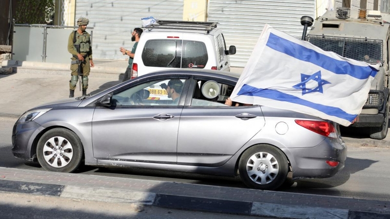 26/05/2022 Un coche circula con una bandera de Israel durante las protestas palestinas en Huwara