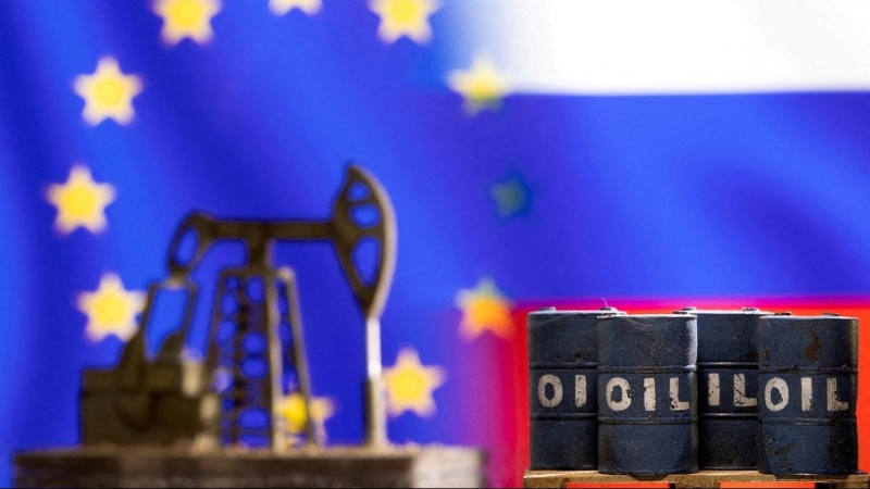 Una imagen de archivo muestra miniaturas de barriles de crudo frente a las banderas de Rusia y la UE