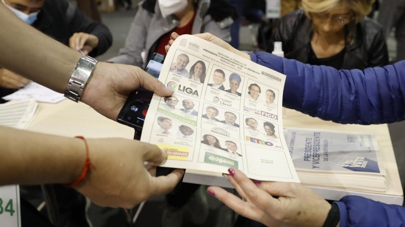 Un hombre recibe una tarjeta electoral hoy, durante la jornada de elecciones para elegir presidente de Colombia para el periodo 2022-2026, en el recinto de Corferias en Bogotá (Colombia).