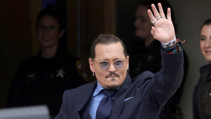 El actor Johnny Depp hace un gesto al salir del juzgado de circuito del condado de Fairfax