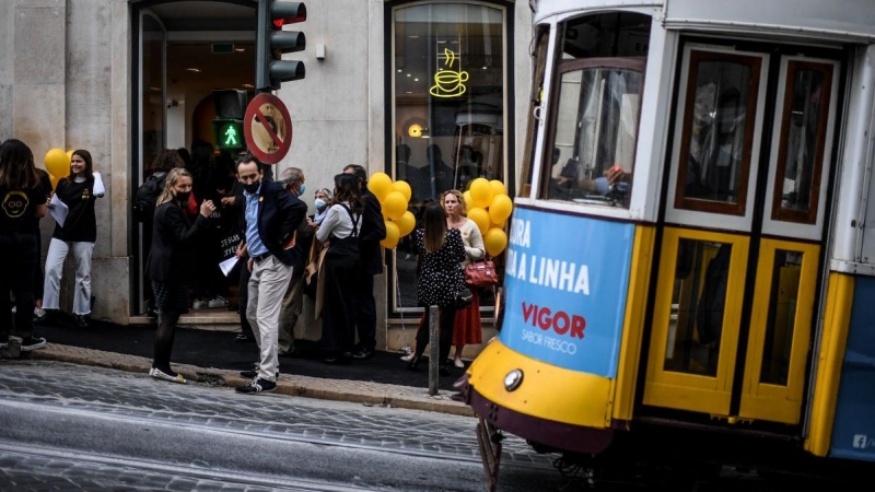 Varios viandantes aguardan el paso del tranvía en Lisboa el 20 de noviembre de 2021.