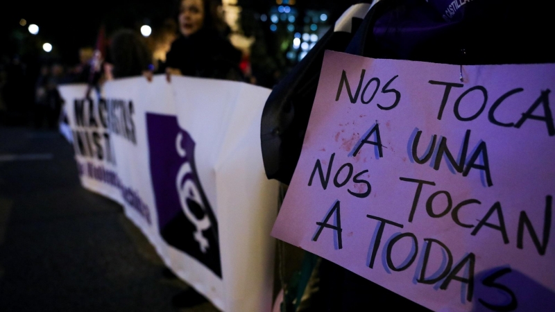 Una mujer sostiene un cartel en el que se lee 'nos tocan a una, nos tocan a todas' en una manifestación feminista en Madrid.