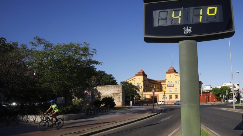 Un ciclista pasa junto a un termómetro que marca 41 grados a última hora de la tarde este jueves, en una jornada marcada por el intenso calor en Córdoba.