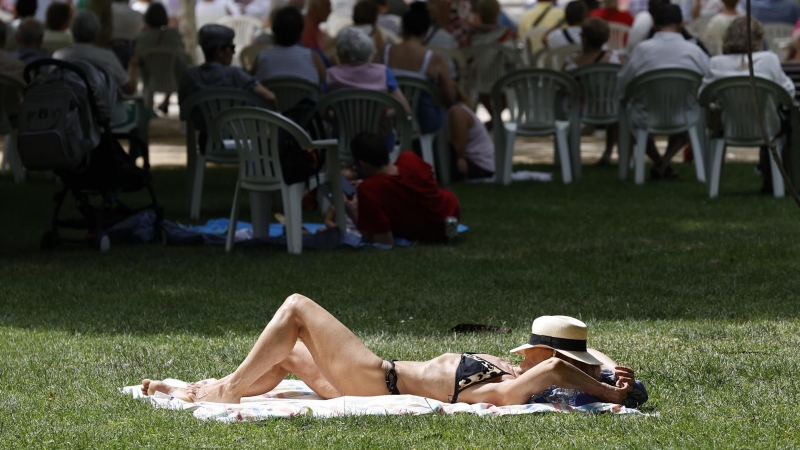 Una mujer toma el sol en el parque del Retiro en Madrid, donde este domingo se clausura la Feria del Libro