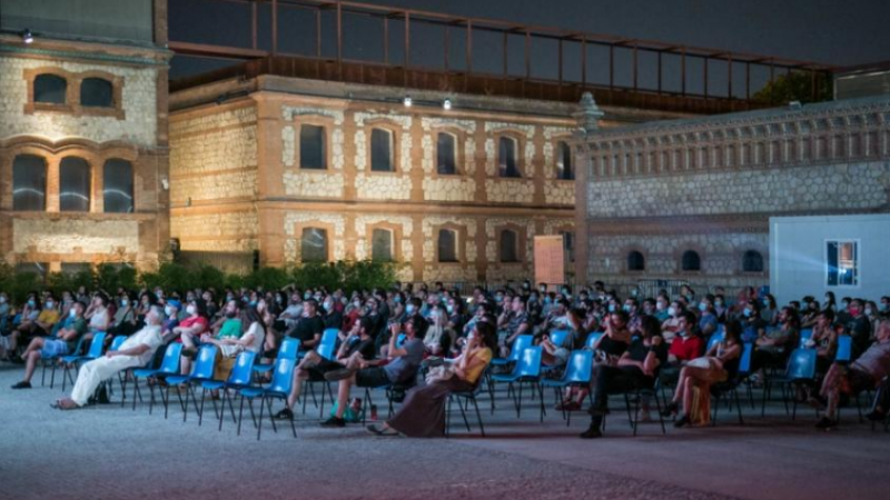 Un grupo de gente disfruta de una película proyectada en el cine de verano de Matadero (Madrid).