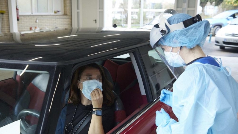 14/06/2022. Una sanitaria le realiza la prueba PCR a una mujer en su coche durante la realización de PCR en el autocovid instalado en el Hospital Militar, a 28 de diciembre de 2021 en Sevilla.