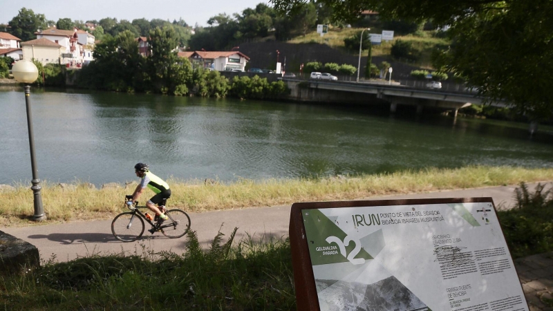 Un ciclista pasa por las inmediaciones del río Bidasoa a su paso por Irún este sábado.