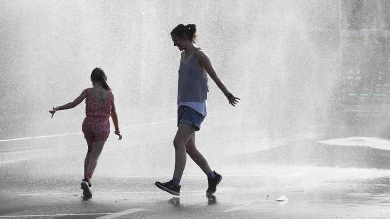 Dos personas se refrescan durante la ola de calor en Vitoria.