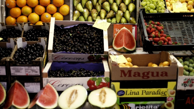 Naranjas, peras, limones, uvas, sandías, melones, fresas y cerezas en un mercado.