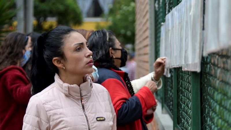19/06/2022 Varias personas consultan la información electoral en un colegio electoral de Bogotá, en Colombia