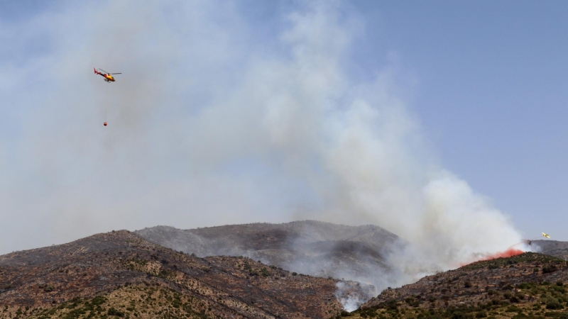 19/06/2022 - Un helicòpter dels Bombers es dirigeix a una columna de fum a la serra de Sant Mamet, a Artesa de Segre.