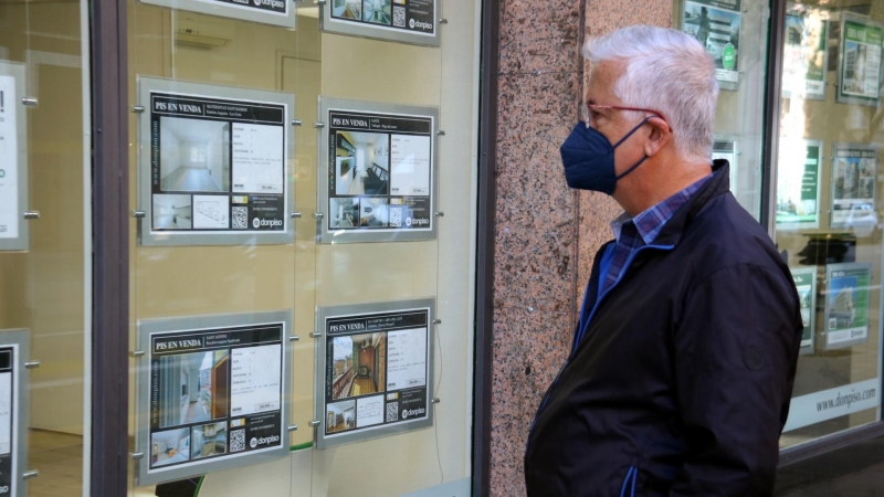 26/10/2021 - Un home mira anuncis de pisos en una immobiliària.