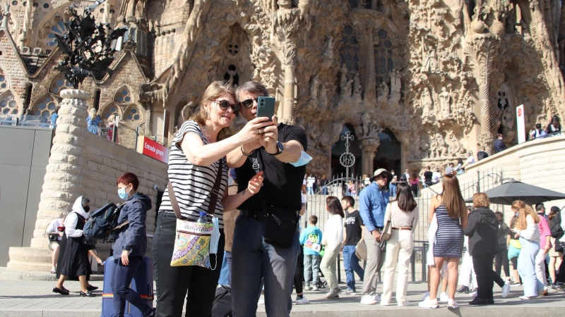 Dos turistes es fan una 'selfie' davant la Sagrada Família.