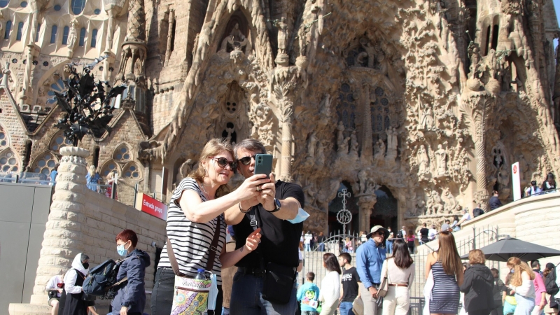 Dos turistes es fan una 'selfie' davant la Sagrada Família.