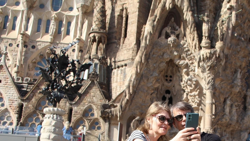 Dos turistes es fan una 'selfie' davant la Sagrada Família.