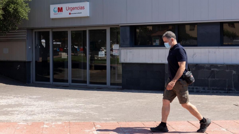 Un hombre pasea con mascarilla, frente a la entrada de urgencias del ambulatorio de Moralzarzal, a 26 de junio de 2021, en Madrid.