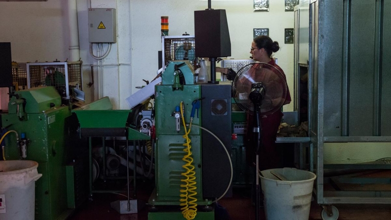 Una trabajadora maneja maquinaria en una fábrica de corchos en Girona, a 16 de junio de 2022.