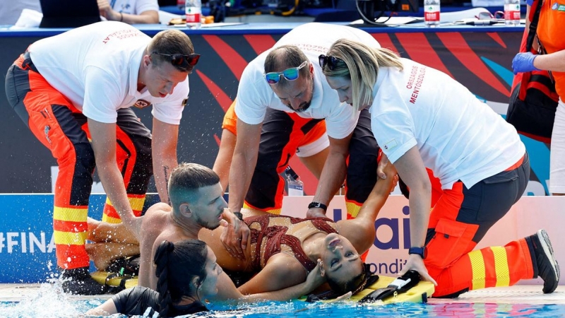 La española Andrea Fuentes saca a la nadadora Anita Álvarez del agua con la ayuda de los servicios de emergencia.