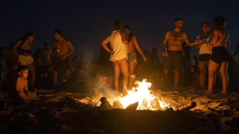 Centenares de personas frente a una hoguera en la playa de la Malvarrosa durante la Noche de San Juan, a 23 de junio de 2022, en Valencia, Comunidad Valenciana.