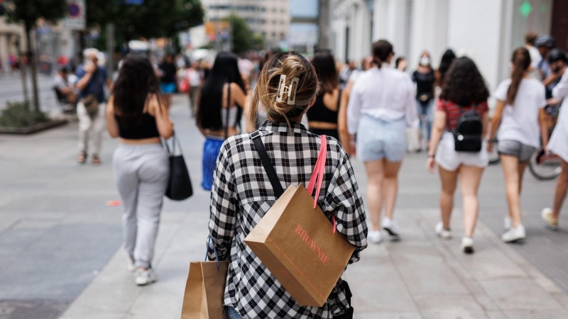 21/06/2022-Una mujer pasea con bolsas por la Gran Vía, a 21 de junio, en Madrid