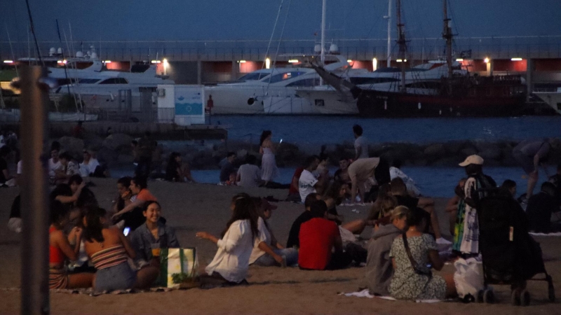 Un grup de gent sopa a la platja del Somorrostro de Barcelona a la revetlla de Sant Joan.