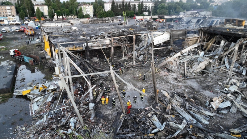 Bomberos trabajan en las ruinas de un centro comercial alcanzado por un ataque con misiles rusos en Kremenchuk, en la región de Poltava, Ucrania. (28 de junio de 2022)