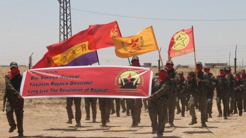 Los miembros de RC que combatieron en Siria pasean una bandera republicana, durante un acto del Batallón de la Libertad de Rojava.