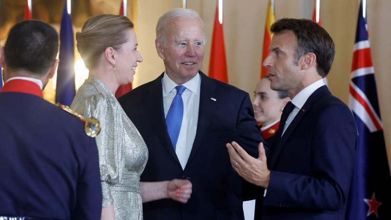 El presidente de Francia, Emmanuel Macron, la primera ministra de Dinamarca, Mette Frederiksen, y el presidente de los EEUU, Joe Biden, conversan mientras esperan para la foto de familia antes de la cena de gala de los líderes de la OTAN en el Palacio Rea