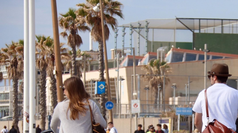 Dos turistes amb les maletes per la Barceloneta.