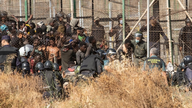 29/06/2022 Un miembro de las fuerzas de seguridad marroquí se lleva detenido a un migrante desde el lado español de la frontera con Melilla