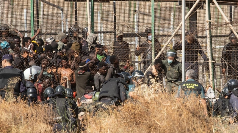 29/06/2022 Un miembro de las fuerzas de seguridad marroquí se lleva detenido a un migrante desde el lado español de la frontera con Melilla