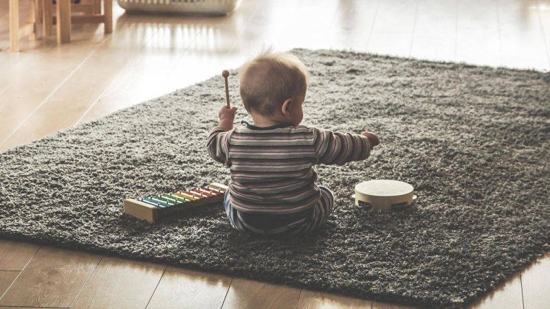 Fotografía de un bebé de espaldas jugando