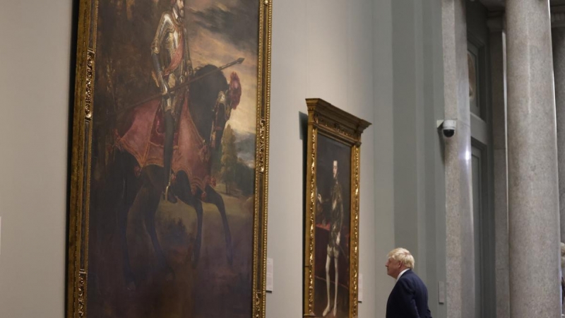 El primer ministro británico Boris Johnson contempla el cuadro de Tiziano 'Carlos V a caballo' a su llegada al Museo del Prado, donde el jefe del ejecutivo español ofrece una cena a los jefes de Estado y jefes de Gobierno que participan en la cumbre de la